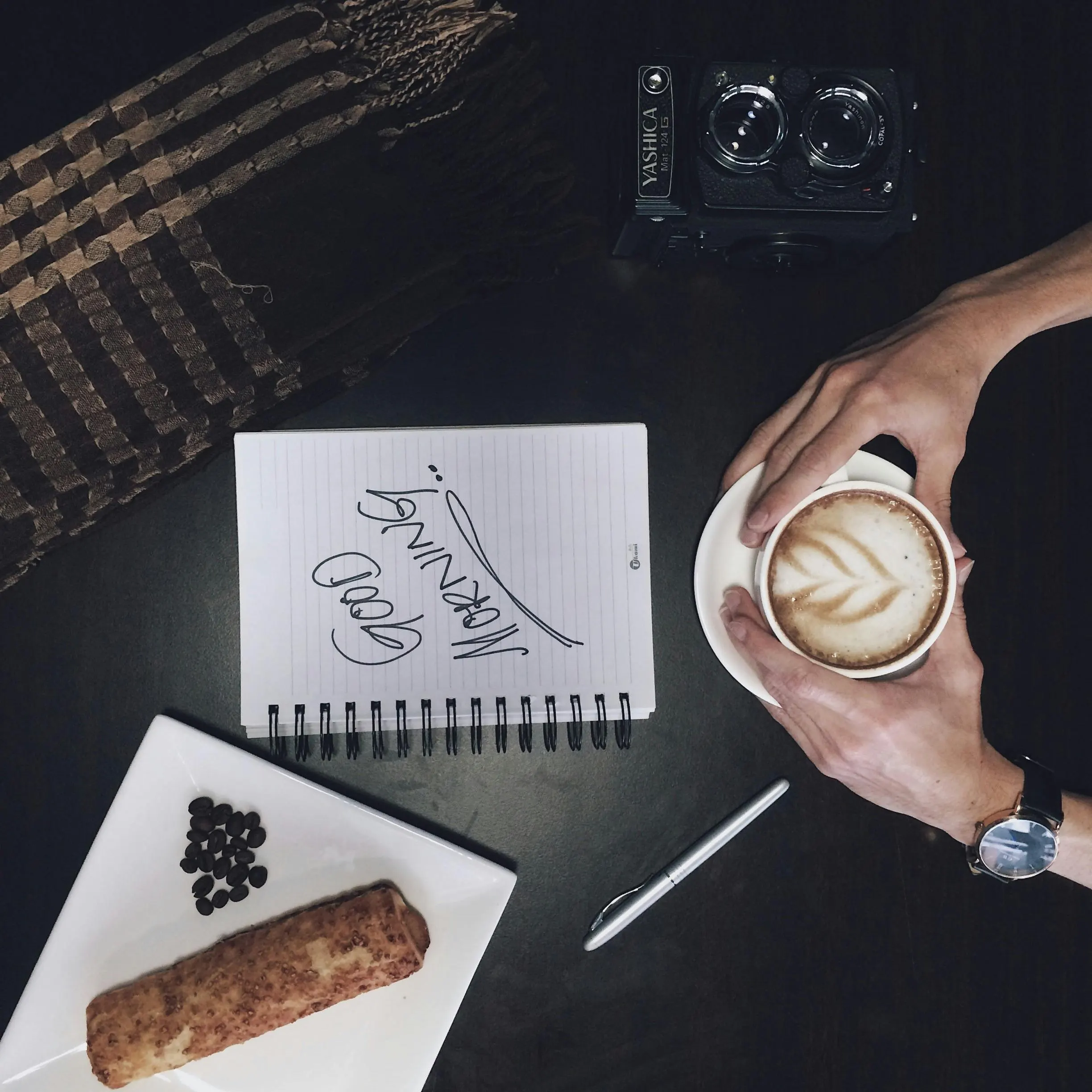 Open travel notebook, map and tea on a pale Scandinavian planning table