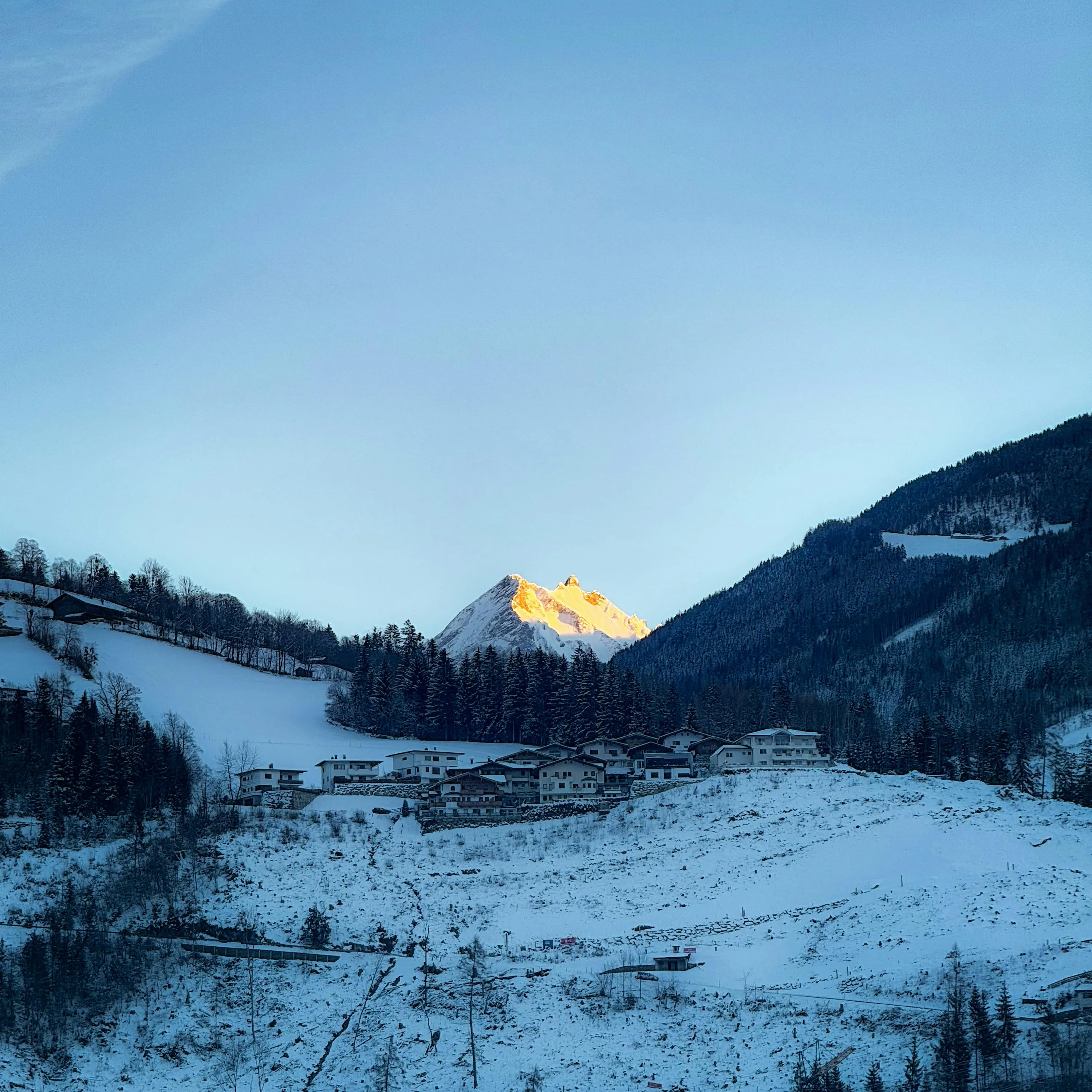 Premium mountain lodge at dawn with snow light and muted teal travel mood