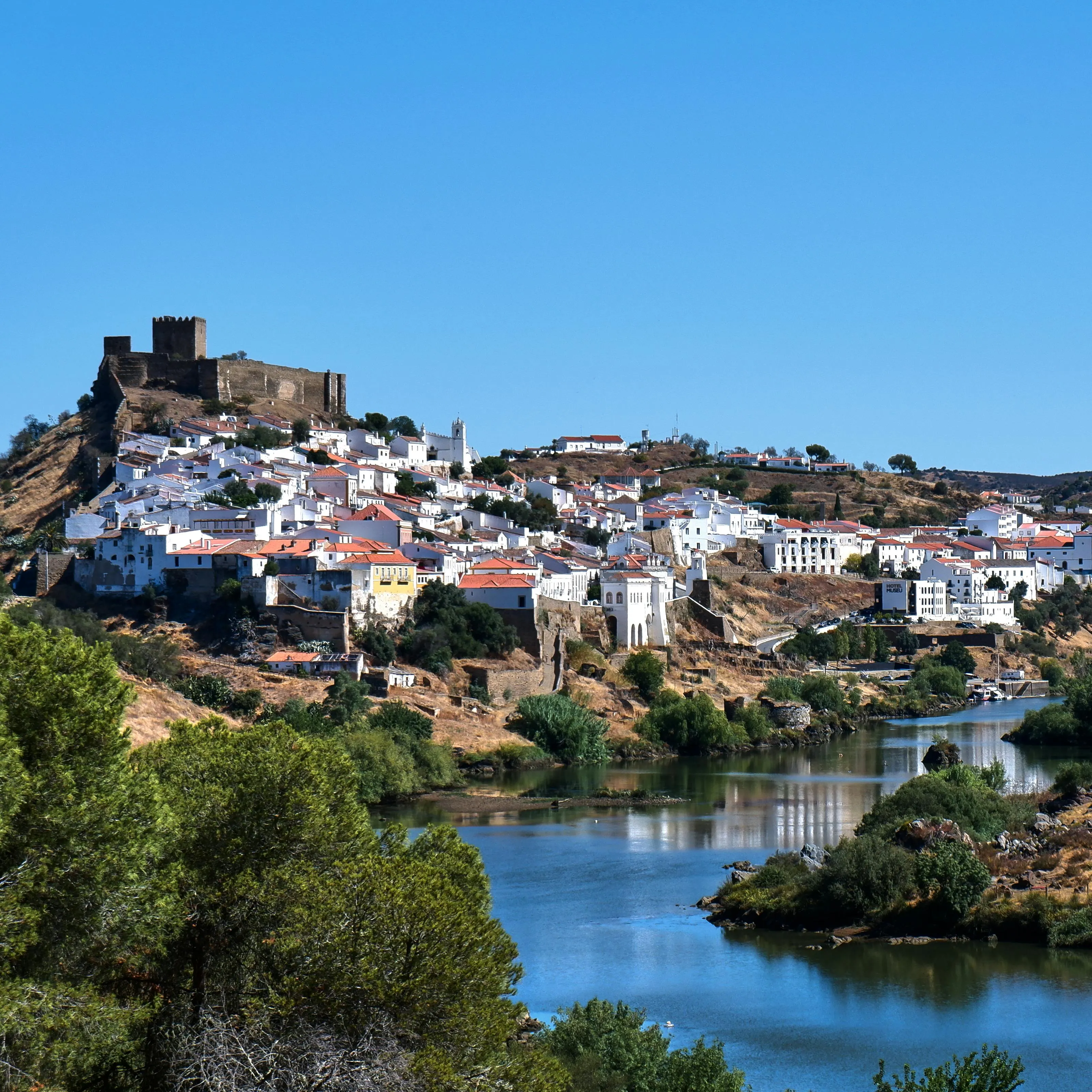 Quiet coastal village with white houses and muted teal sea