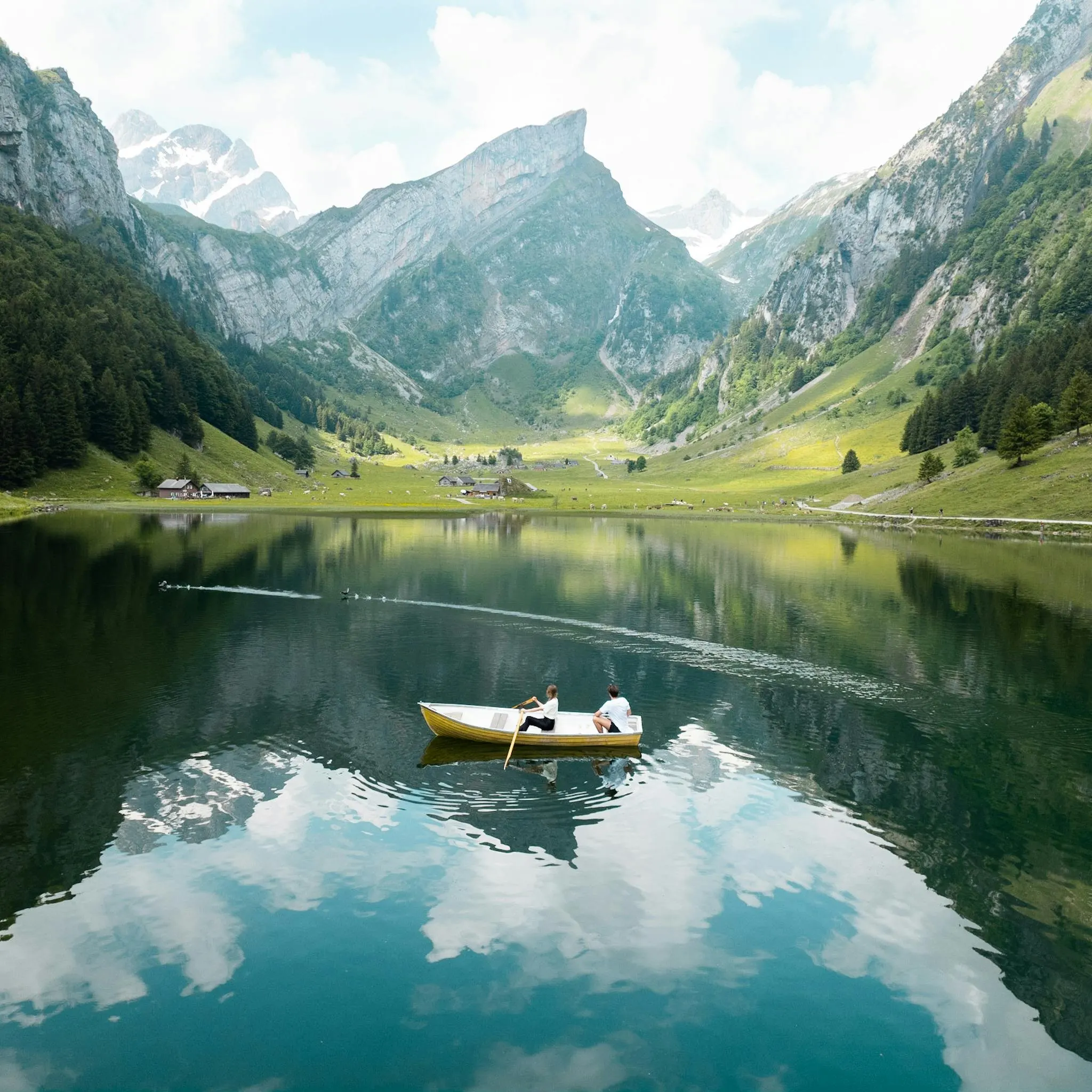 Travellers watching pale evening light over a dramatic fjord