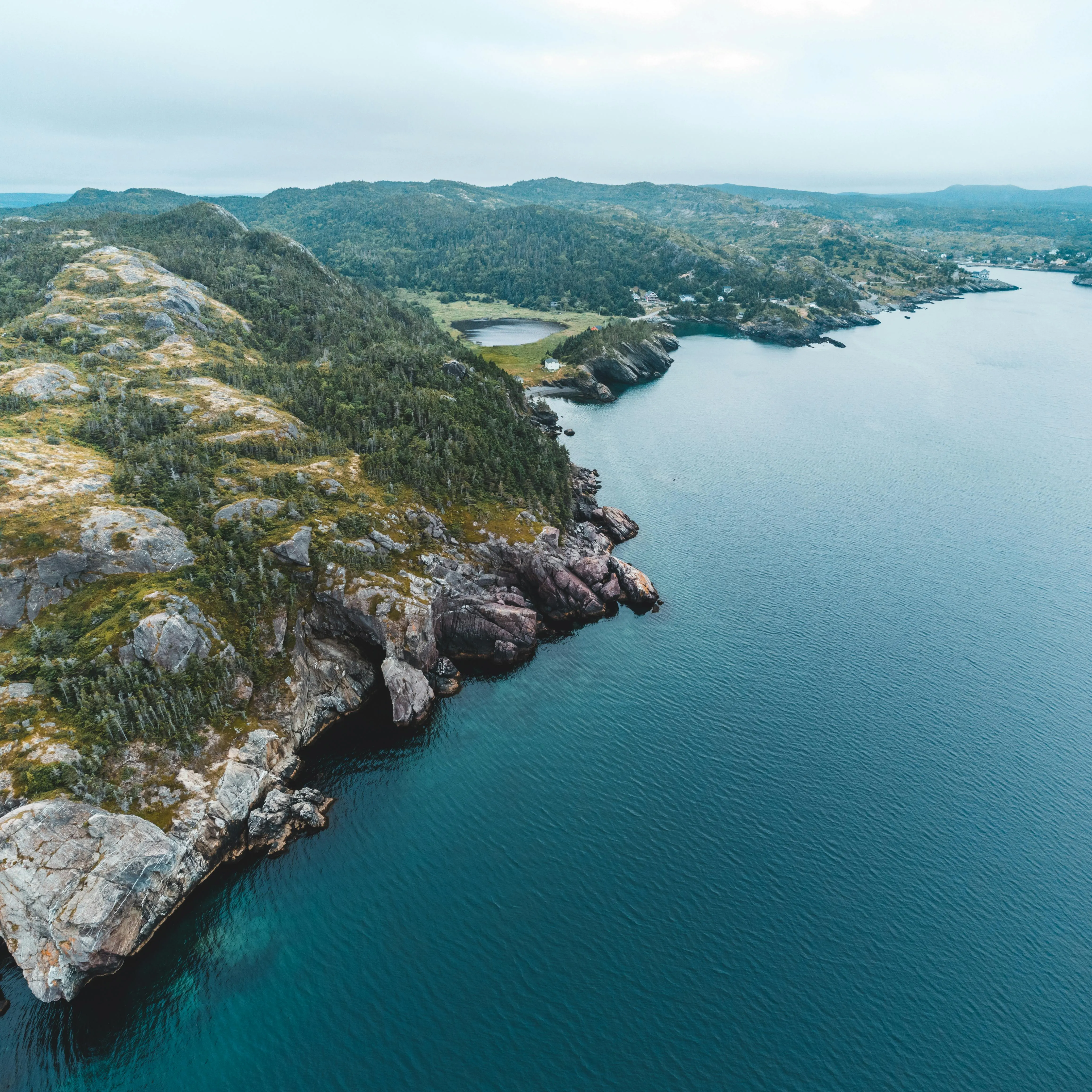 Muted scenic coastline with pale water and clean horizon for island travel